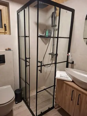 a glass shower in a bathroom with a sink at Kuće za odmor Banstolija - Fruška Gora in Čortanovci