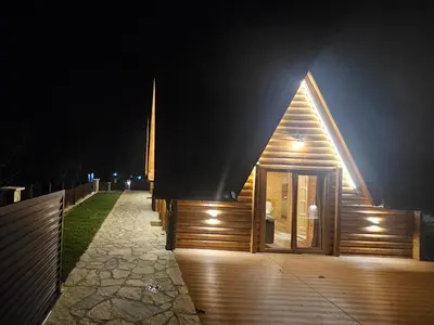 a wooden building with a window at night at Kuće za odmor Banstolija - Fruška Gora in Čortanovci