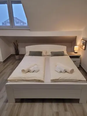 a large white bed with two pillows on it at Beosan in Belgrade