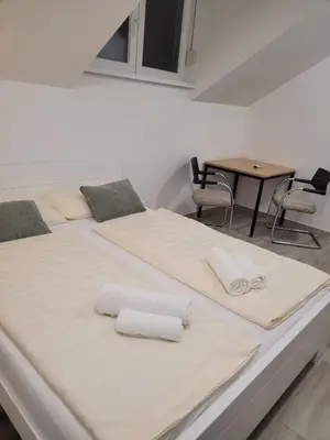two beds in a room with a table at Beosan in Belgrade
