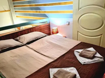 a large bed with two towels on top of it at Apartment Cabin-Style in Belgrade