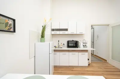 a kitchen with white cabinets and a refrigerator at Apartment Moonstone 4 in Belgrade