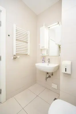 a white bathroom with a sink and a mirror at Apartment Moonstone 4 in Belgrade