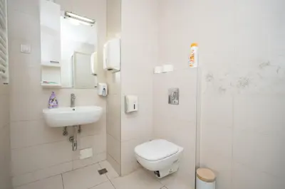 a white bathroom with a toilet and a sink at Apartment Moonstone 4 in Belgrade