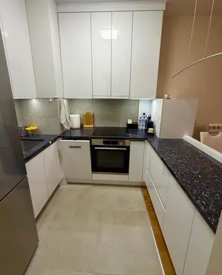 a kitchen with white cabinets and black counter tops at Belgrade Forest Gate near center in Belgrade
