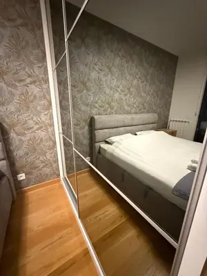 a small bedroom with a bed and a glass wall at Belgrade Forest Gate near center in Belgrade
