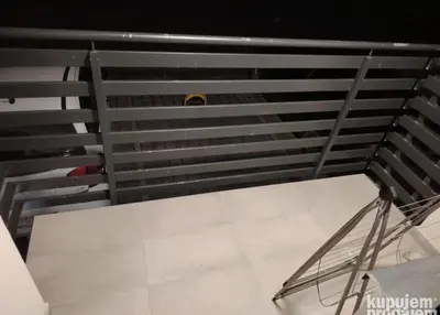 a metal staircase in a room with white tile at Furkan Home in Surčin