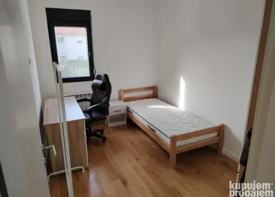 a bedroom with a bed and a desk and a chair at Furkan Home in Surčin