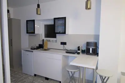 a kitchen with a counter with a sink and stools at Infinity in Belgrade
