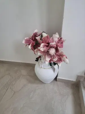 a white vase with pink flowers in it at Infinity in Belgrade