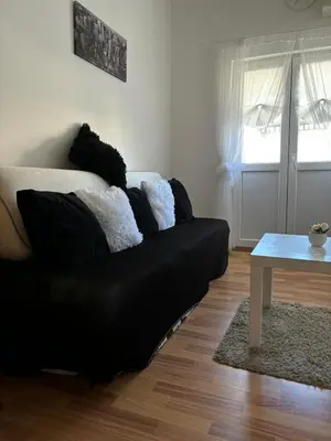 a black couch in a living room with a table at Kneginje Ljubice apartment in Belgrade