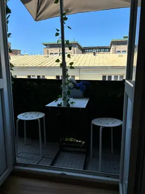 a balcony with two stools and a table with a plant at Kneginje Ljubice apartment in Belgrade