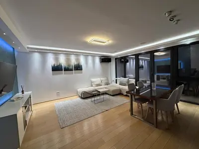 a living room with a couch and a dining room at Vist Sava Center Residence in Belgrade