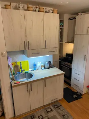 a kitchen with white cabinets and a sink at Penthouse in Belgrade