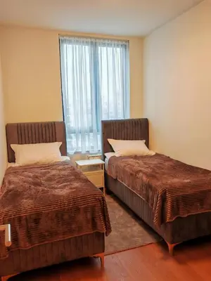 two beds in a room with a window at SnowWhite Belgrade Waterfront in Belgrade