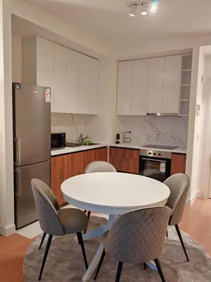 a kitchen with a white table and chairs at SnowWhite Belgrade Waterfront in Belgrade