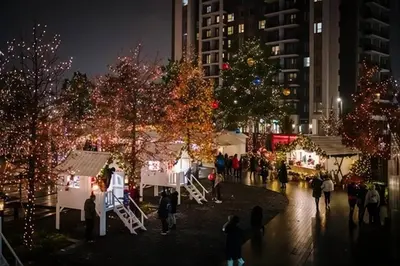 a group of people walking around a christmas market at night at SnowWhite Belgrade Waterfront in Belgrade