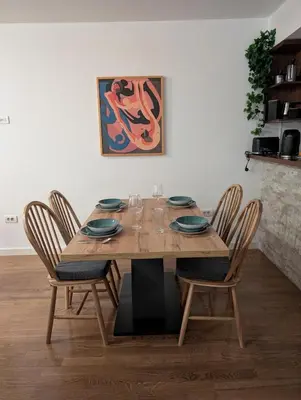 a dining room table with four chairs and a painting at Nova Vracar - Luxury Apartment & Private Parking in Belgrade