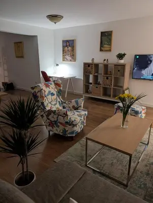 a living room with a chair and a table at Nova Vracar - Luxury Apartment & Private Parking in Belgrade