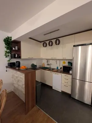 a kitchen with white cabinets and a stainless steel refrigerator at Nova Vracar - Luxury Apartment & Private Parking in Belgrade