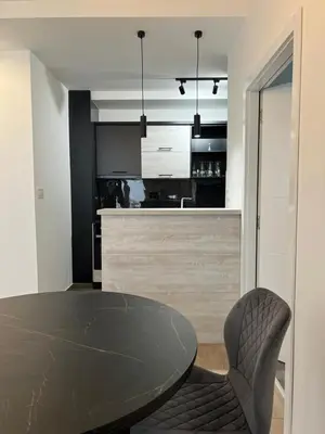 a dining room with a table and a kitchen at Tesla Lux Apartman in Belgrade