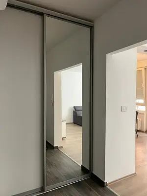 a room with sliding glass doors and a living room at Tesla Lux Apartman in Belgrade