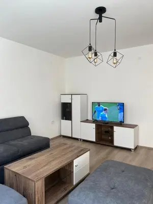 a living room with a couch and a flat screen tv at Tesla Lux Apartman in Belgrade