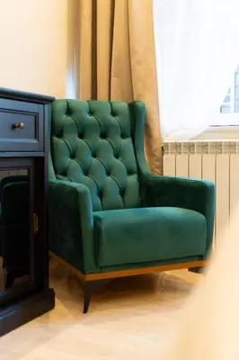 a green couch sitting next to a window at Luxury Apartment Old Town City Center in Belgrade