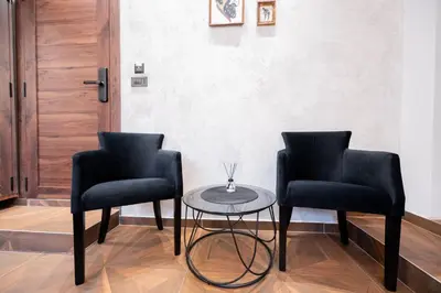 two black chairs and a table in a room at Stella Di Notte City Center Studios in Belgrade