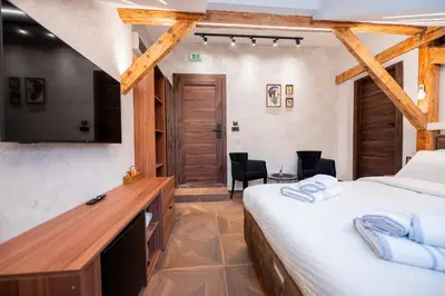 a bedroom with a bed and a desk with a television at Stella Di Notte City Center Studios in Belgrade