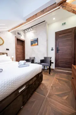 a hotel room with a bed and two chairs at Stella Di Notte City Center Studios in Belgrade