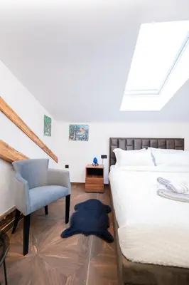 a bedroom with a bed and a chair at Stella Di Notte City Center Studios in Belgrade