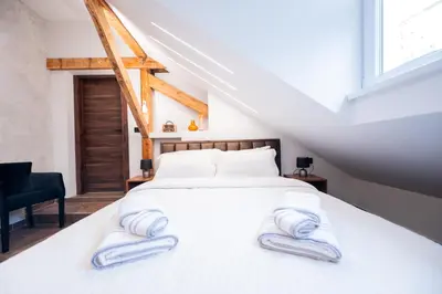 a bedroom with a white bed with slippers on it at Stella Di Notte City Center Studios in Belgrade