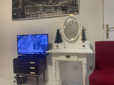 a desk with a television and a mirror on it at Ena's apartman in Belgrade