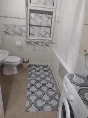 a bathroom with a sink and a toilet and a window at Ena's apartman in Belgrade