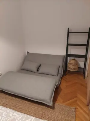 a bed in the corner of a room with a ladder at Jana's in Belgrade