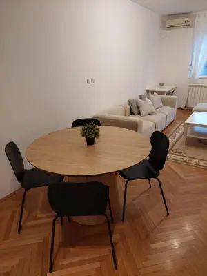 a living room with a table and chairs and a couch at Jana's in Belgrade