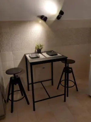 a table and two stools in a room at Jana's in Belgrade