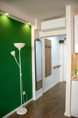 a green wall in a room with a lamp at LUX apartment 15 min walk to Knez Mihajlova in Belgrade
