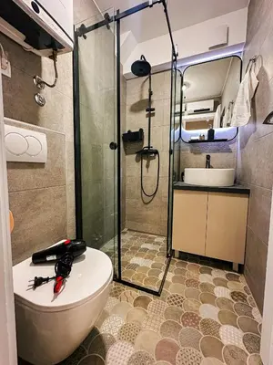 a bathroom with a shower and a toilet and a sink at Astor Wellness apartman in Belgrade
