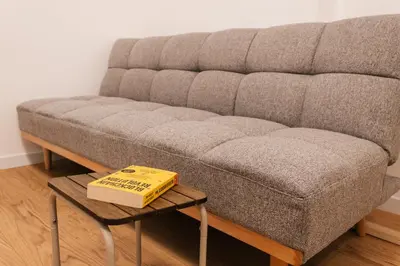 a book sitting on a table next to a couch at Astor Wellness apartman in Belgrade