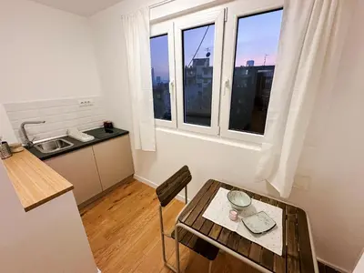 a small kitchen with a table and a sink at Astor Wellness apartman in Belgrade