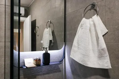 a bathroom with a white towel hanging on a wall at Astor Wellness apartman in Belgrade