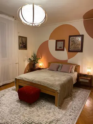 a bedroom with a large bed and a red chair at Belgrade Retro City Center Apt in Belgrade