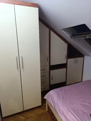 a bedroom with white cabinets and a bed at Apartman 32 in Inđija