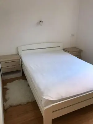 a white bed in a room with two night stands at Visnjica in Belgrade