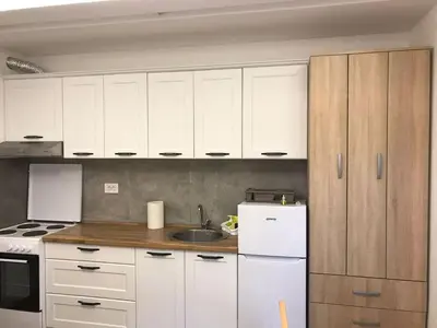 a kitchen with white cabinets and a white refrigerator at Visnjica in Belgrade