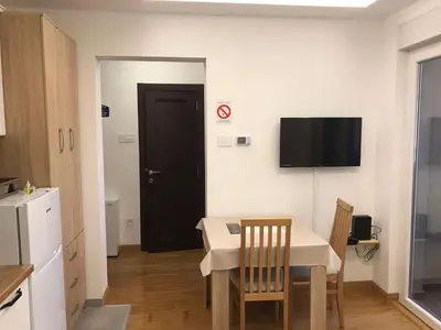 a small room with a table and a tv on the wall at Visnjica in Belgrade