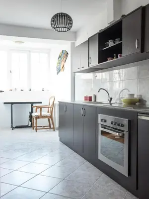 a kitchen with grey cabinets and a table in the background at Apartment Marshall Resavska in Belgrade