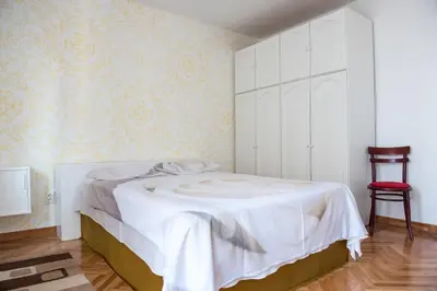 a bedroom with a white bed and a red chair at Apartment Marshall Resavska in Belgrade